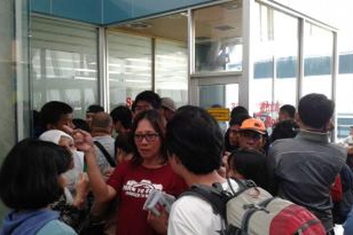 Penumpang Lion Air berkerumun di depan ruang rapat para petinggi Angkasa Pura II di Terminal 3 Bandara Soekarno-Hatta, Jumat (20/2/2015). Mereka menunggu kejelasan setelah sempat dikabarkan tidak ada pesawat yang tersedia.