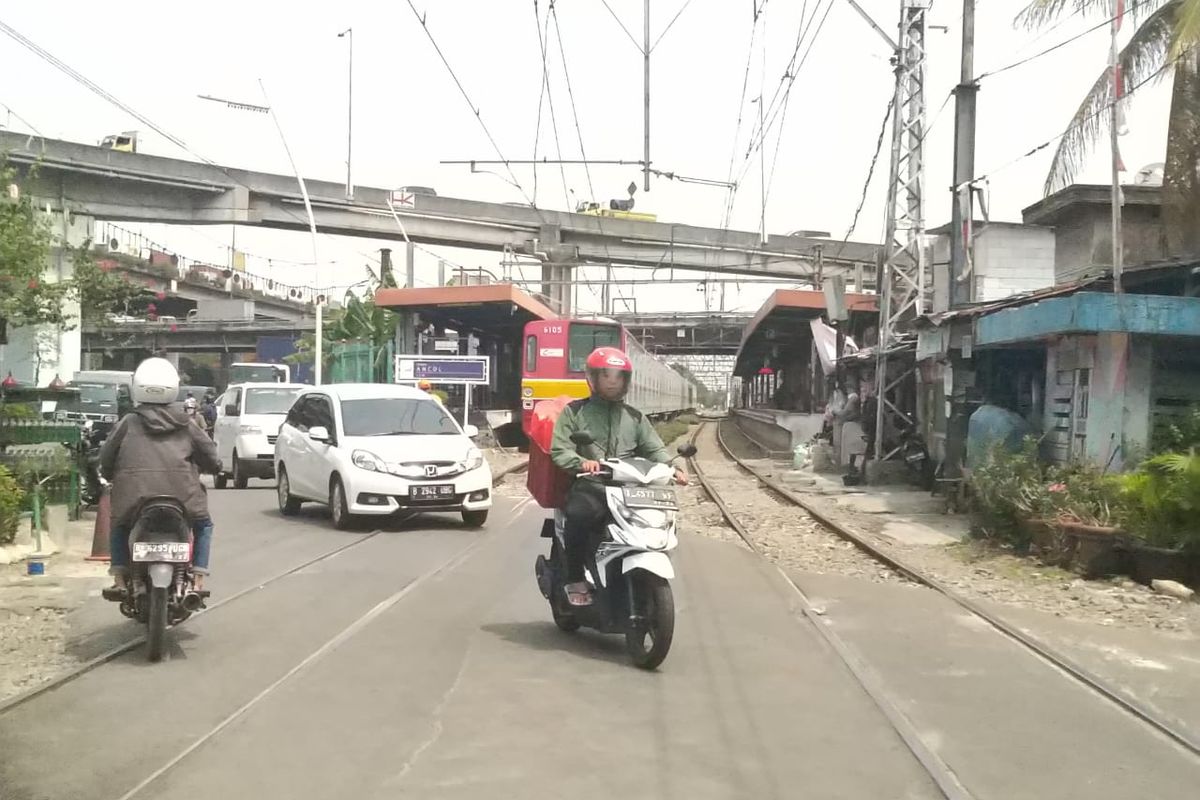 Para pengguna jalan melewati jalur perlintasan kereta tanpa palang di Stasiun Ancol.