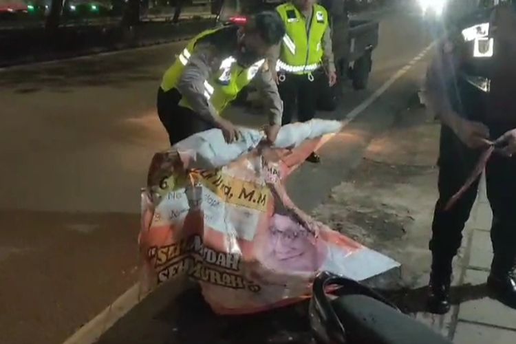 Polisi membenahi baliho caleg PKS yang ditabrak pengendara motor di Jalan Daan Mogot, Jakarta Barat, Kamis (4/1/2024). 