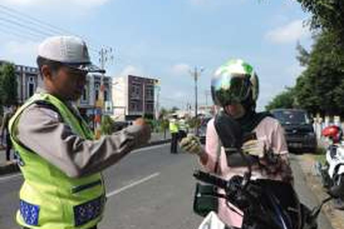 Salah seorang personil Satlantas Polres Bireuen, mengecek kelengkapan surat kendaraan bermotor dalam razia simpatik di depan SMAN 2 Bireuen. Rabu (2/3). DESI