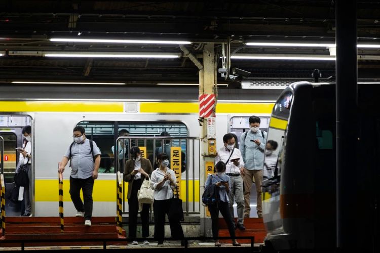 Orang-orang yang mengenakan masker menunggu kereta api yang mendekat di sebuah stasiun di Tokyo, Kamis, 9 September 2021.