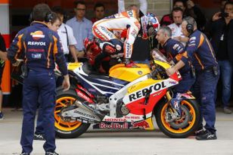 Pebalap Repsol Honda asal Spanyol, Marc Marquez, berlatih perpindah motor saat menjalani sesi pemanasan GP Americas di Austin, Minggu (12/4/2015).