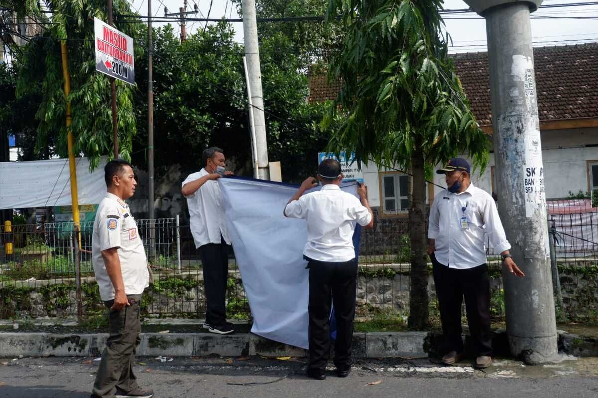 Petugas saat melepas spanduk yang mengandung konten provokatif menuju Pilpres 2024. Spanduk tersebut terpasang di wilayah Kabupaten Sleman. (Foto dokumentasi Satpol PP Sleman)