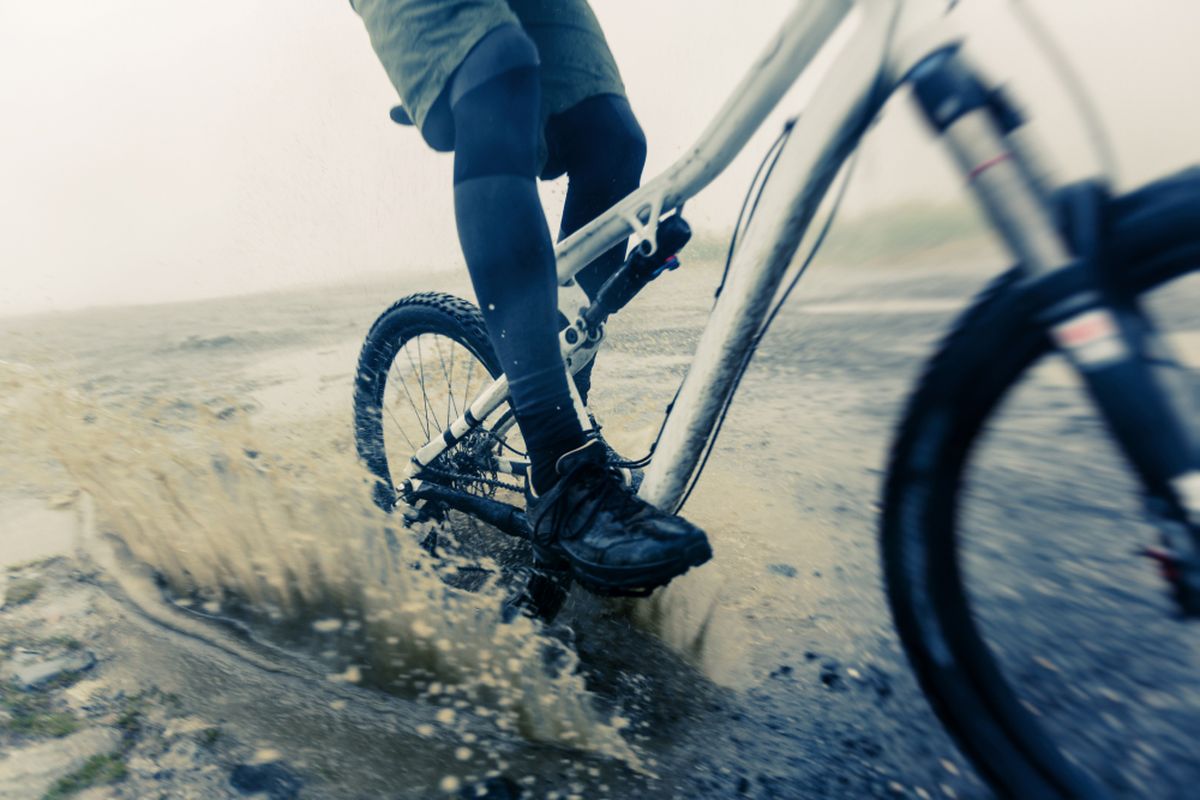 Sepeda gunung melewati genangan air dan lumpur