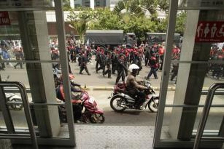 Buruh melewati halte transjakarta di kawasan Bundaran Hotel Indonesia, Jakarta, Rabu (1/5/2013). Transjakarta jurusan Kota-Blok M berhenti beroperasi dikarenakan ratusan ribu buruh dari Jabodetabek turun ke jalan dan berunjuk rasa di Jakarta pada peringatan Hari Buruh Sedunia.