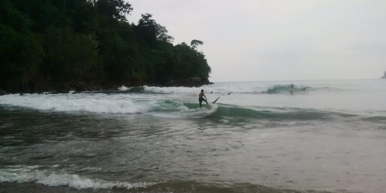 Wisatawan mancanegara berselancar di Pantai Wedi Awu, Malang, Jawa Timur, Minggu (12/6/2016).