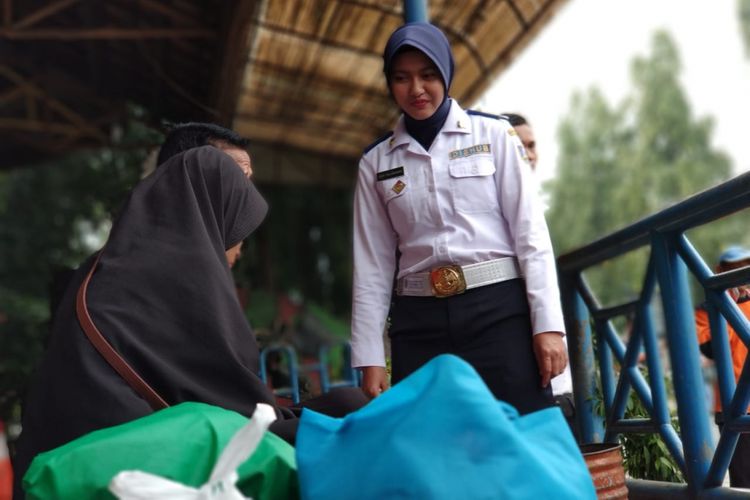 Dishub wanita tetap senyum manis di teriknya terminal Kampung Rambutan, Rabu (6/6/2018)