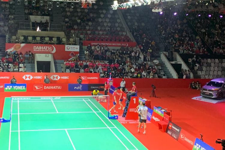 Panitia Indonesia Masters 2022 masuk ke lapangan pertandingan untuk membenahi karpet.