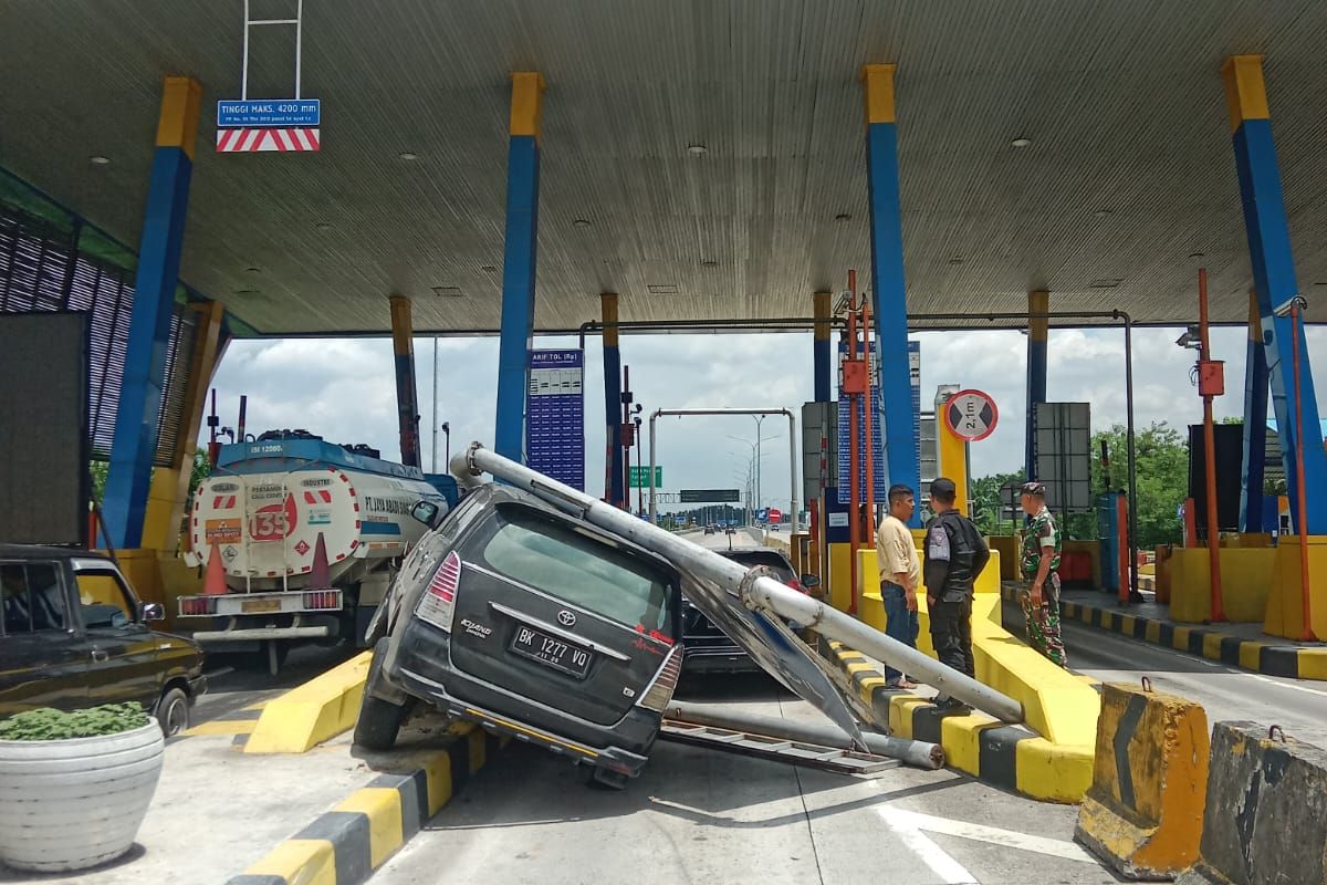 Polisi mengevakuasi mobil yang ringsek tertimpa tiang di Exit Tol Lama Tebing Tinggi, Minggu (21/4/2024)