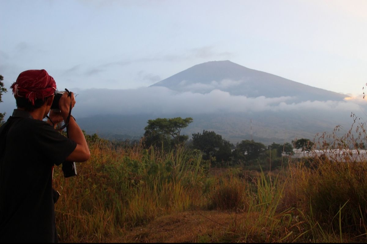 Seorang wisatawan memotret Gunung Rinjani, di Desa Sembalun  Kabupaten Lombok Timur. Sabtu (15/6/2019) sejumlah wisatawan telah mulai mendaki Gunung Rinjani melalui jalur Sembalun. Balai Taman Nasional Gunung Rinjanin (BTNGR) NTB, telah membuka kembali ijin pendakian pasca-gempa yang mengguncang Lombok, Agustus 2018 silam. 