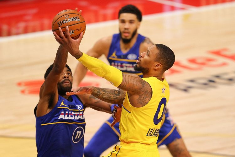 Damian Lillard (kanan) dari tim LeBron James berduel dengan Kyrie Irving (kiri) dari tim Kevin Durant pada pertandingan NBA All-Star 2021 di State Farm Arena, Atlanta, pada Senin (8/3/2021) pagi WIB.