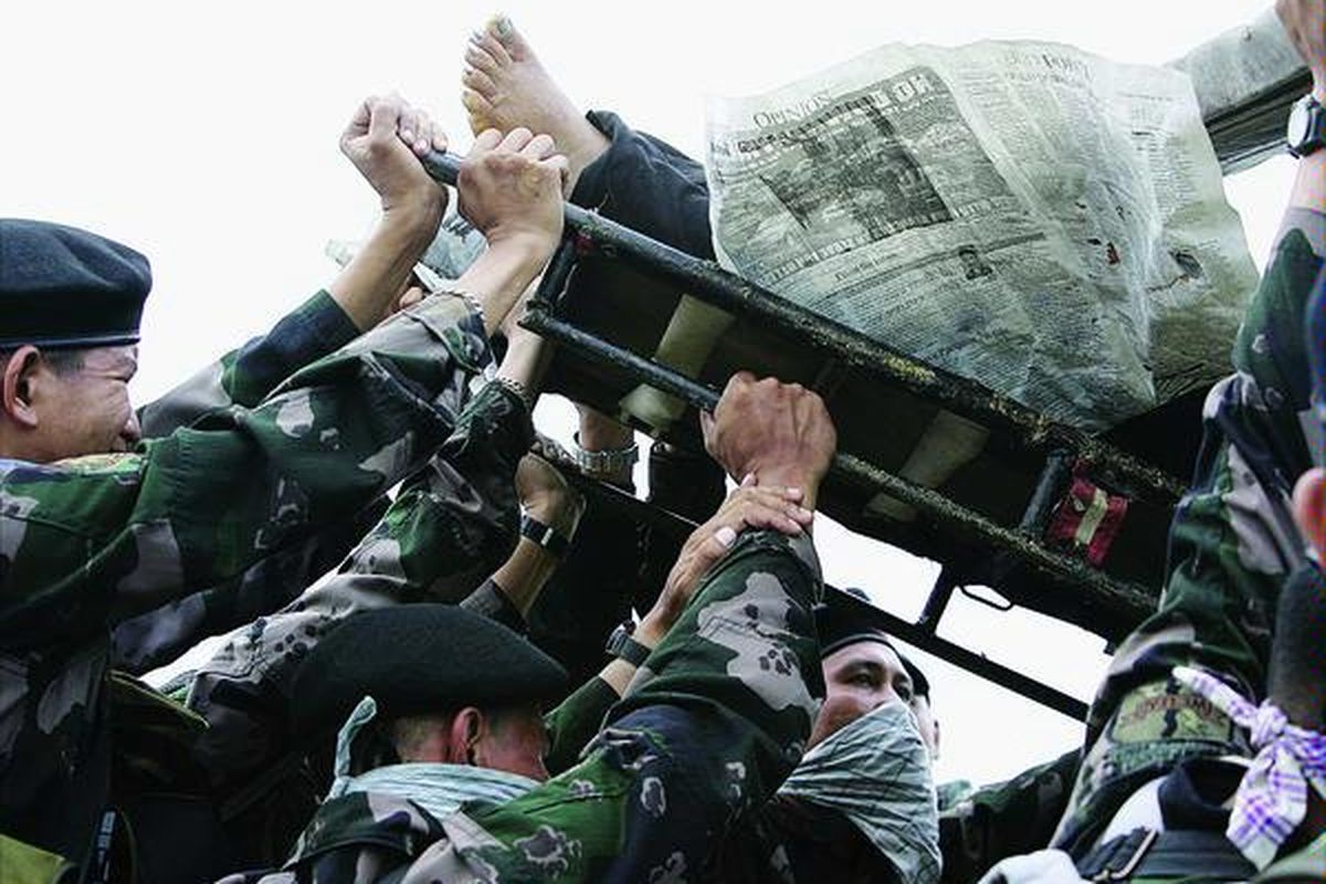 Aparat keamanan mengangkut seorang korban pembantaian di perbukitan Datu Ampatuan, Provinsi Maguindanao, Filipina selatan, Selasa (24/11). Sejumlah wartawan dan keluarga politisi lokal menjadi korban persaingan politik, dalam rangka memperebutkan posisi gubernur pada pemilu Mei 2010. Filipina sudah terbiasa menghadapi pembunuhan bertujuan politik menjelang pemilu.