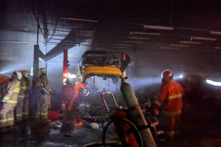 Proses pendinginan mobil yang terbakar di bengkel kawasan Cilandak, Jakarta Selatan, Minggu (30/5/2021).