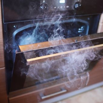 Ilustrasi oven mengeluarkan asap. 