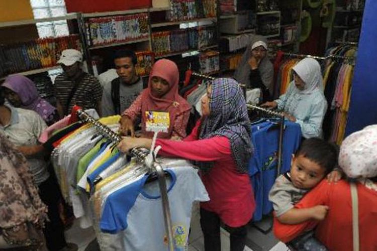 Pemudik berbelanja kaos di gerai industri kaos Dagadu, Jalan Pakuningratan, Yogyakarta, Jumat (24/8/2012). Kaos hasil industri kreatif merupakan salah satu komoditi yang banyak dicari pemudik selama berada di Yogyakarta.  