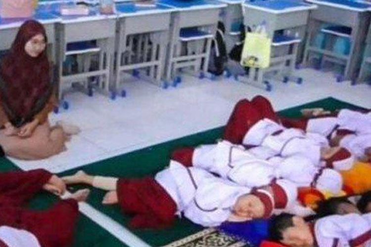 Siswa Sekolah Dasar (SD) Muhammadiyah 4 Zamzam Sidoarjo, Jawa Timur, saat tidur siang didampingi oleh gurunya, Senin (4/12/2023)