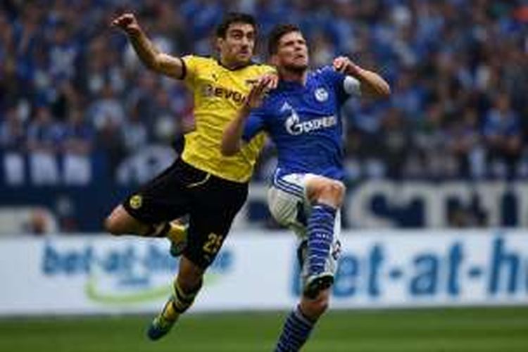 Bek Dortmund, Sokratis, berduel udara dengan striker Schalke, Klaas Jan Huntelaar, saat kedua tim beradu di Veltins Arena, Minggu (10/4/2016). 