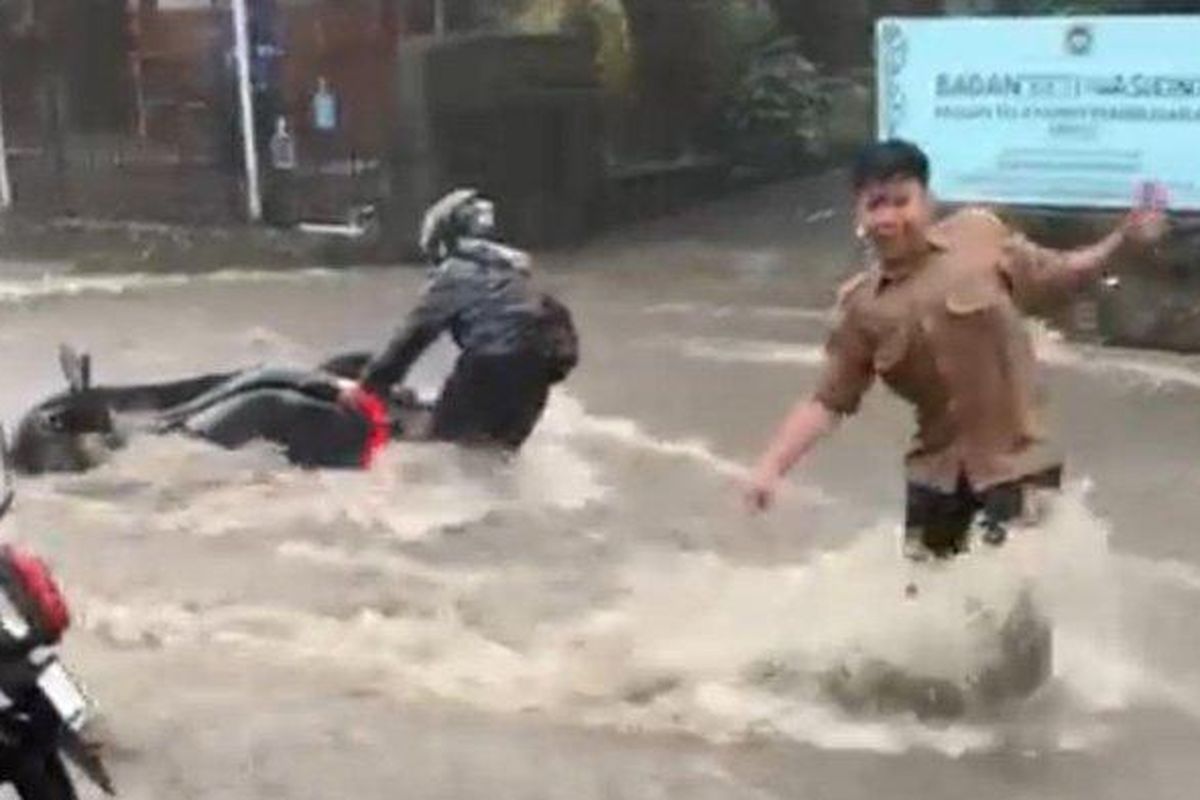 Pengendara motor tengah berusaha menyelematkan kendaraan yang terseret arus banjir di Jalan Maribaya, Desa Kayuambon, Lembang, Jumat (23/5/2025).