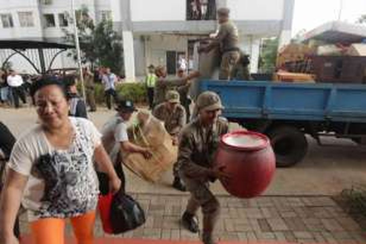 Warga asal Kalijodo dibantu Satpol PP menurunkan barang saat tiba di rumah susun sewa Pulogebang, Jakarta Timur, Rabu (24/2/2016). Hari ini sebanyak 86 Kepala Keluarga asal Kalijodo mulai pindah dan menempati unit rusun di Blok H Rusun Pulogebang.