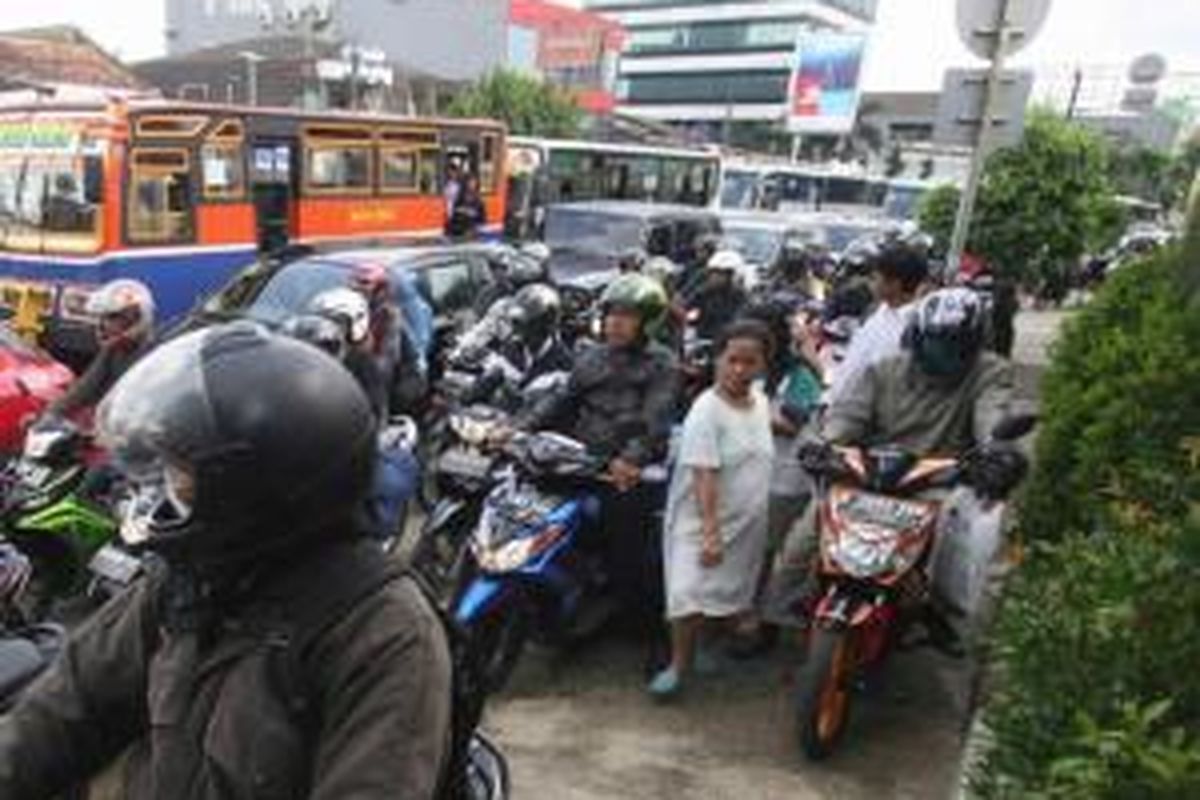 Pejalan kaki mencari jalan di antara sepeda motor yang memenuhi jalan hingga ke trotorar di Jalan Mampang Prapatan, Jakarta, Selasa (3/4/2012). Karena macet, sepeda motor kerap mengambil jatah trotoar yang menjadi tempat melintas pejalan kaki.