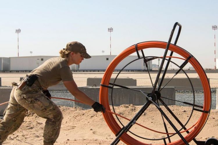 Tentara senior Kelsie Burt mengeluarkan gulungan kabel komunikasi untuk Cargo City yang berlokasi di dekat Bandara Kuwait. Bandara tersebut diklaim bakal menjadi bandara militer terbesar AS di Timur Tengah.