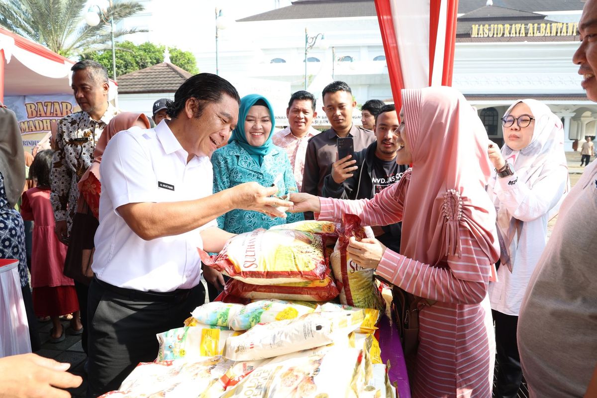 Penjabat (Pj) Gubernur Banten Al Muktabar layani pembeli beras saat menggelar Bazar Ramadhan Provinsi Banten 2024 di halaman Masjid Raya Al-Bantani, Kawasan Pusat Pemerintahan Provinsi Banten (KP3B) Curug, Kota Serang, Kamis (4/4/2024).