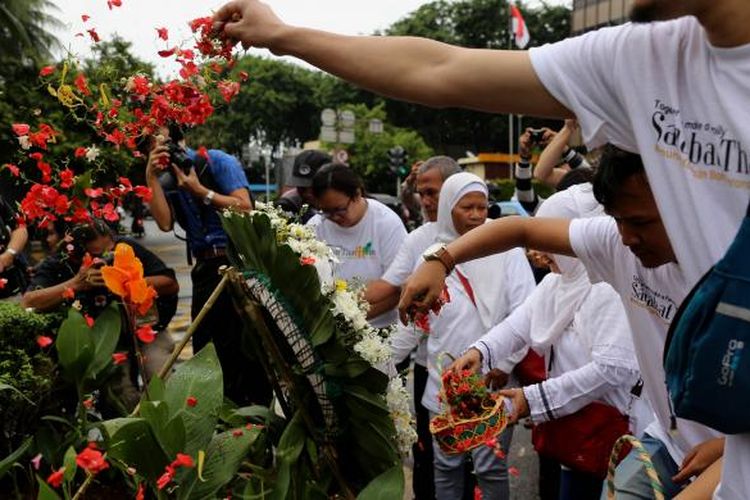 Massa yang tergabung dalam Sahabat Thamrin, Yayasan Penyintas, dan Aliansi Indonesia Damai (AIDA) melakukan tabur bunga di Sarinah, Thamrin, Jakarta, Sabtu (14/1/2017). Mereka mengenang kembali aksi terorisme yang terjadi siang hari tepat setahun lalu.