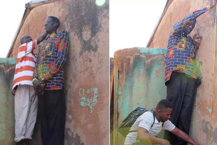 Seorang tetangga berdiri di atas bangku untuk menandai dinding saat mengukur Awuche.