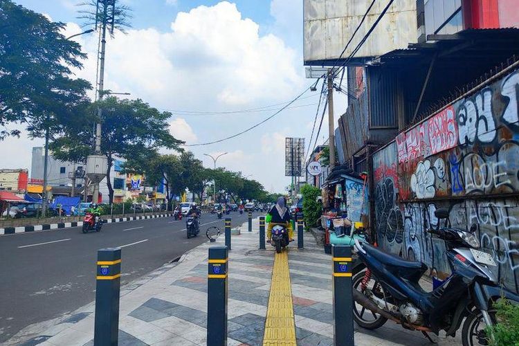 Pengendara motor yang melawan arah dan melintas di trotoar pejalan kaki, Jalan Margonda Raya, Depok, Jumat (9/6/2023).