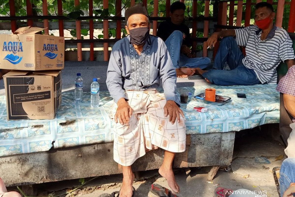 Ketua RT015 RW07 Jati, Suraji (65), berpose di depan kediamannya kawasan Jati, Kecamatan Pulo Gadung, Jakarta Timur, Rabu (1/7/2020), usai memberikan klarifikasi terkait dugaan pungutan liar terhadap distribusi bantuan sosial COVID-19 dari pemerintah provinsi setempat.