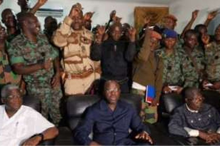 Sejumlah tentara yang menuntut kenaikan gaji berdiri di belakang Menteri Pertahanan Pantai Gading, Alain-Richard Donwahi (kemeja biru). 