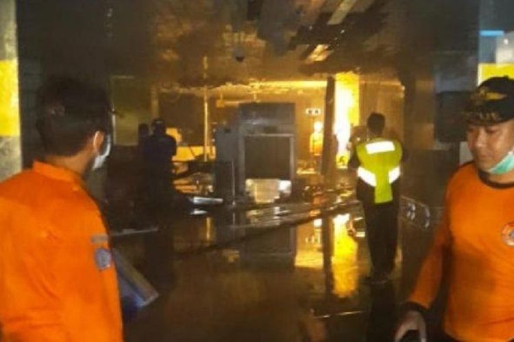 Petugas tengah memadamkan api yang berkobar di area dalam bandara I Gusti Ngurah Rai, Jumat (19/4/2019) sore.