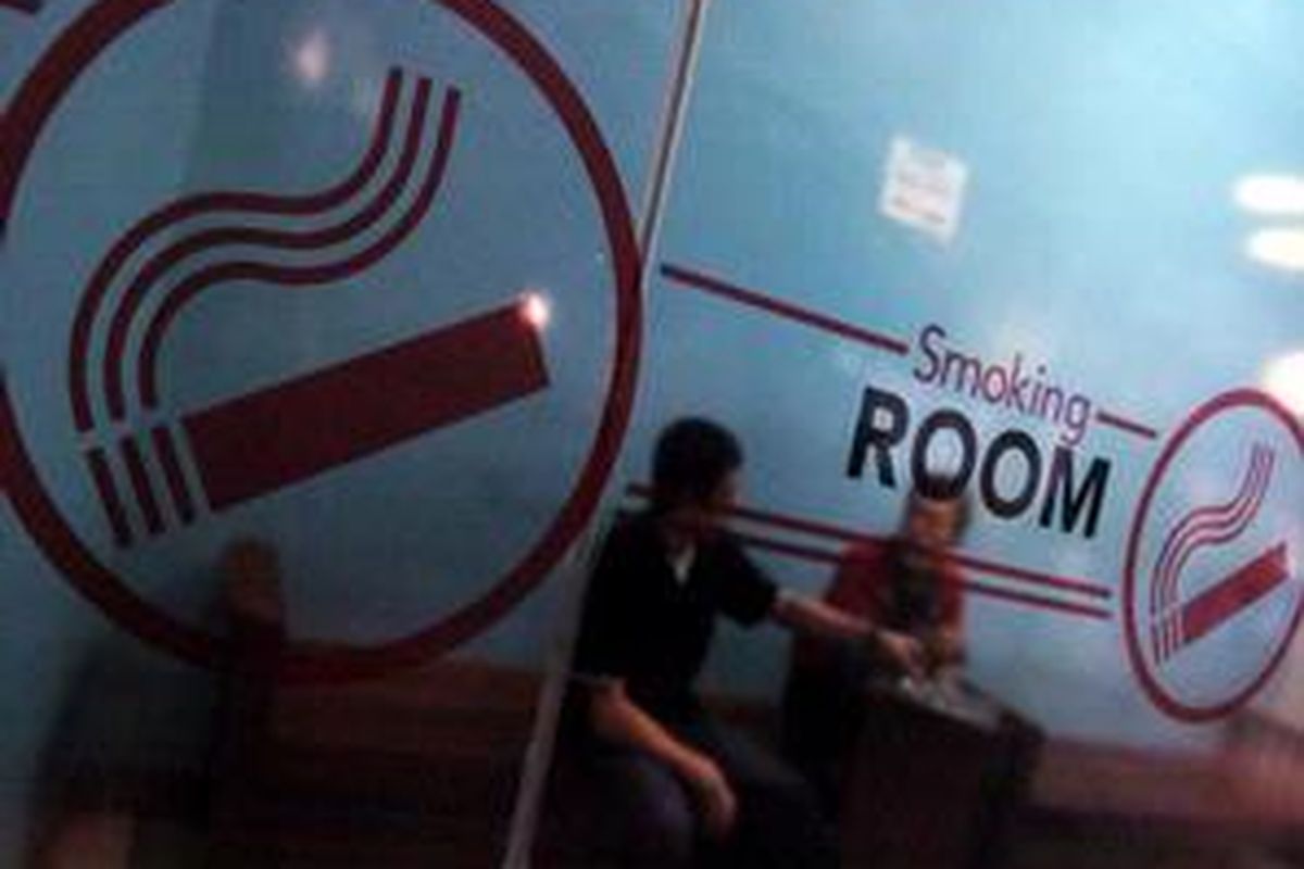 Perokok menggunakan fasilitas ruang merokok yang disediakan salah satu pusat perbelanjaan di Kota Surabaya, Jawa Timur, Rabu (21/10). Pemerintah Kota Surabaya akan menerapkan Perda No 5 tahun 2008 tentang Kawasan Tanpa Rokok dan Kawasan Terbatas Merokok mulai Kamis (22/10). 