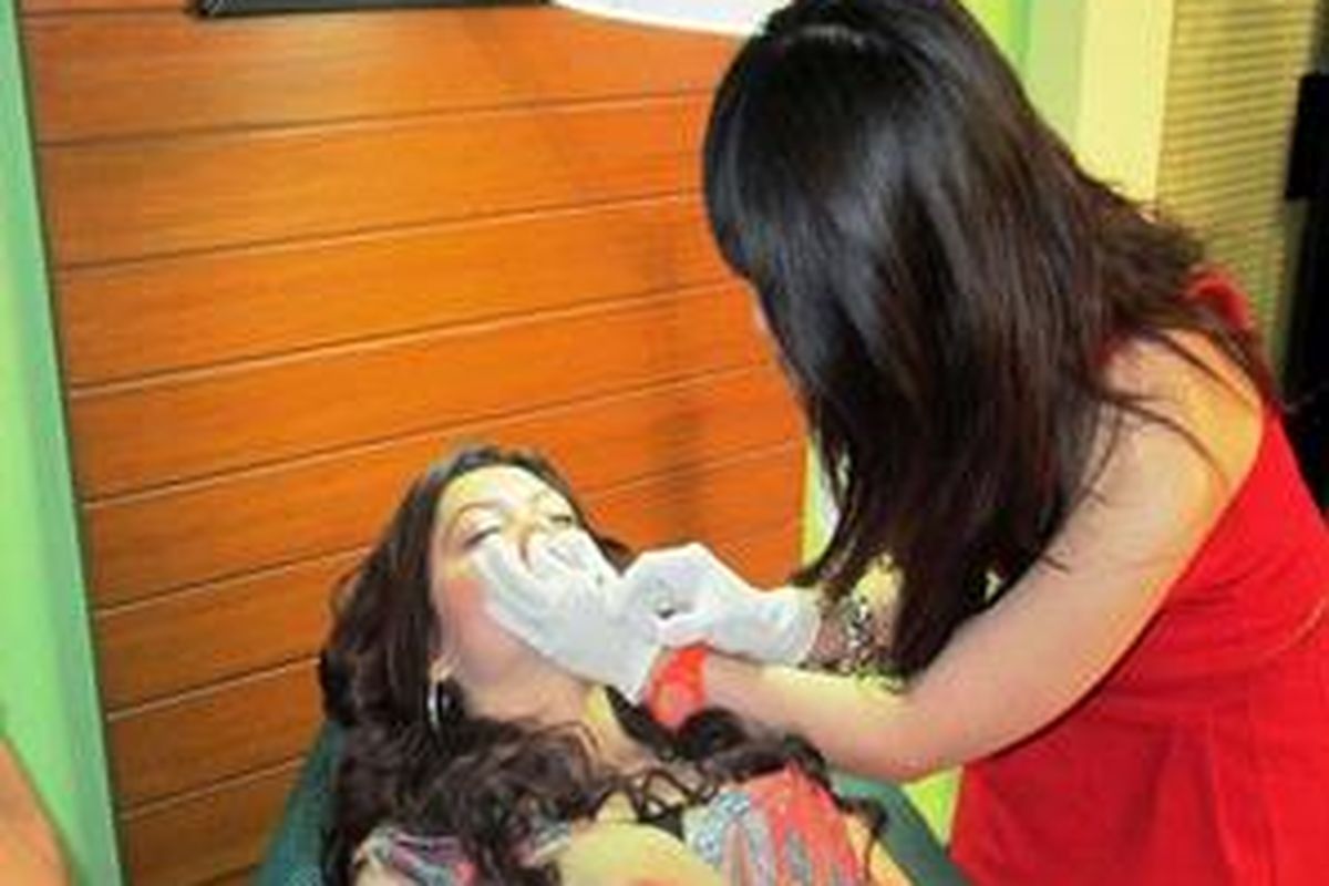 Dr Maya C. Audy tengah melaukan prosedur dermal filler untuk Rina Rachmawati.