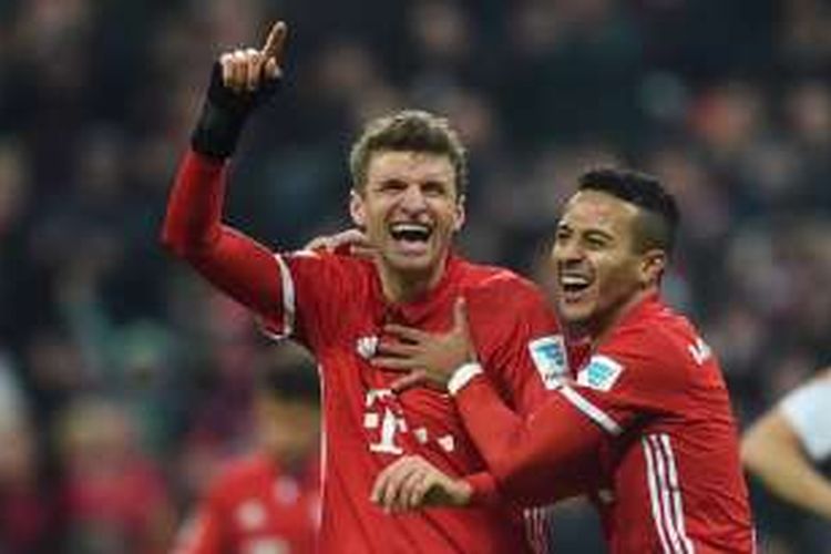 Thomas Mueller merayakan gol pertamanya musim ini bersama Thiago Alcantara saat Bayern Muenchen menang atas Wolfsburg di Allianz Arena, Sabtu (10/12/2016).