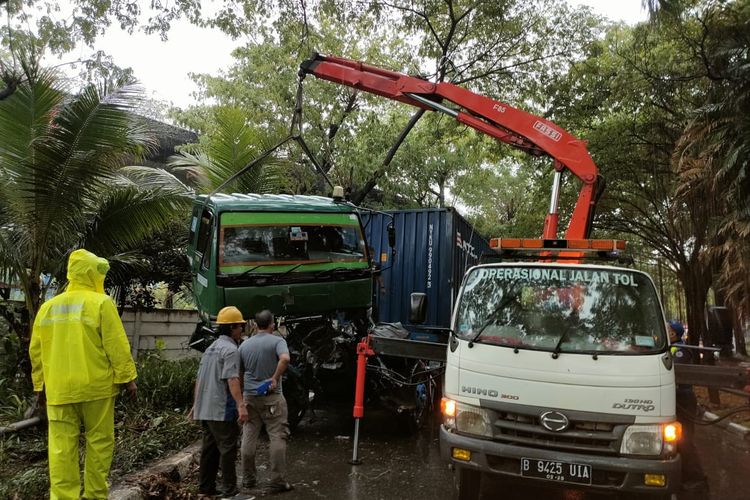 Petugas mengevakusai sebuah truk trailer yang menabrak railing tol Ir Wiyoto Wiyono, di pintu keluar Jembatan Tiga, Penjaringan Jakarta Utara pada Senin (18/10/2021) sore.