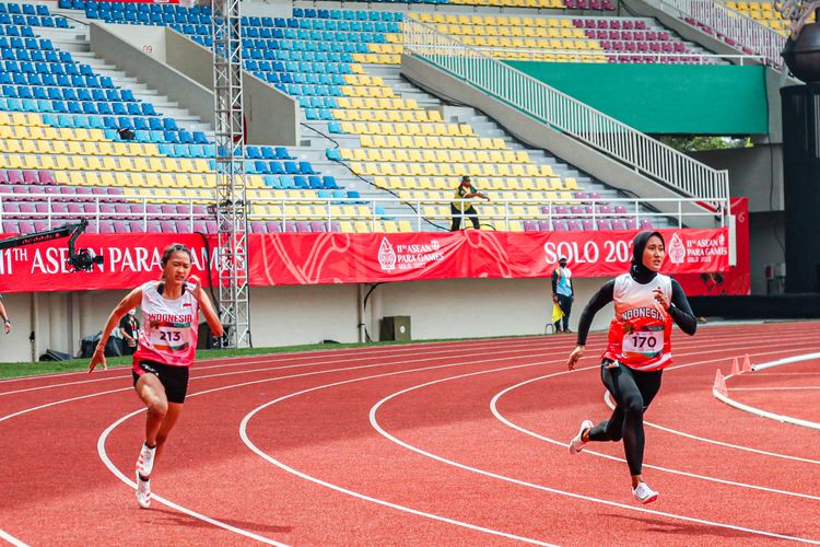 Atlet para atletik Indonesia, Putri Aulia (kanan), meraih medali emas ASEAN Para Games 2022 di Stadion Manahan, Solo, Selasa (2/8/2022).  Putri Aulia mengalahkan rekannya, Ni Wayan Ayu Alvina (kiri) di nomor 200 meter T13.  Indonesia masih kokoh di puncak klasemen ASEAN Para Games 2022.