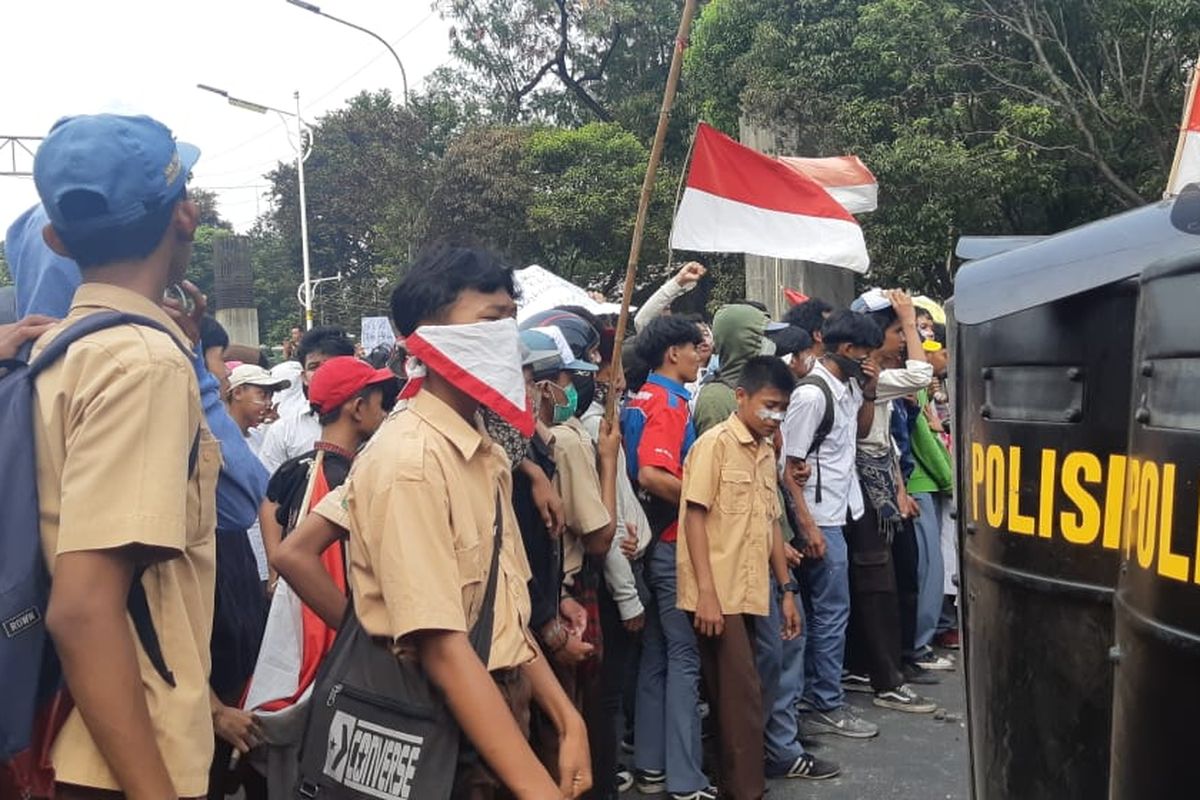 Ratusan pelajar dengan seragam pramuka, SMK, dan STM menyerang aparat kepolisian dari brimob yang sedang bertugas menjaga pintu belakang Gedung DPR/MPR RI, Jakarta Pusat. Pantuan Kompas.com pada Rabu (25/9/2019) siang, sekitar pukul 14.00 WIB, massa dari kalangan pelajar sempat melempari batu ke arah aparat yang sedang bertugas.