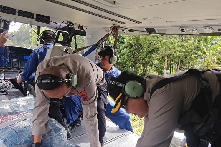 Polisi saat menurunkan bantuan dengan helikopter di lokasi terisolir akibat banjir di Desa Nauli Sitahuis di Kecamatan Sitahuis, Kabupaten Tapanuli Tengah (Tapteng) Sumatera Utara, Minggu (7/12/2025).