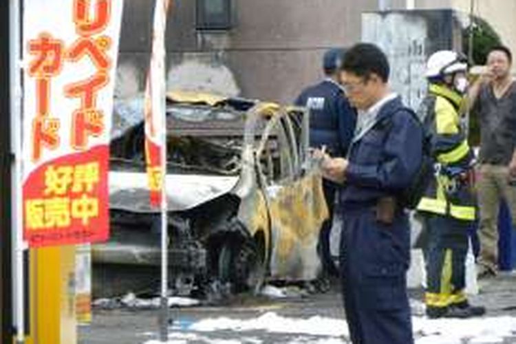 Polisi memeriksa mobil yang hangus akibat ledakan di sebuah taman di kota Utsunomiya, 100 kilometer sebelah utara kota Tokyo, Minggu (23/10/2016).