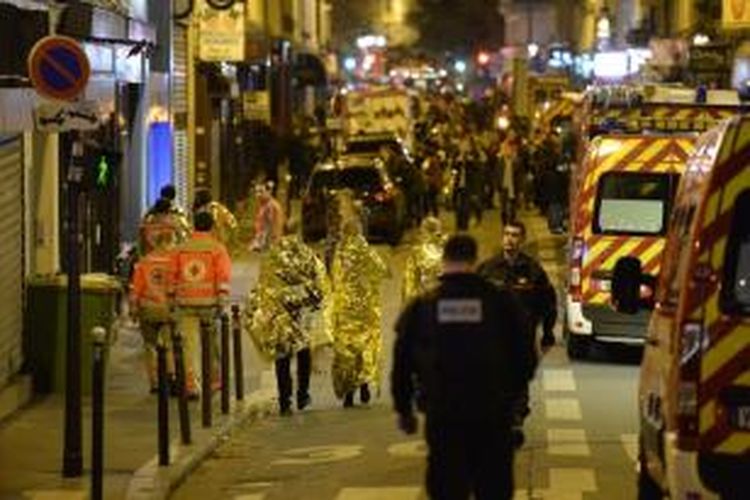 Warga dievakuasi dekat gedung konser musik Bataclan di pusat Kota Paris, Perancsi, Sabtu (14/11/2015) dini hari. Sedikitnya 120 orang tewas dalam serangkaian serangan teror di Paris pada Jumat (13/11/2015) malam.