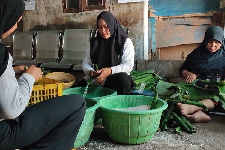 Nurlaela (42), Nurlaeli , dan Yani (62), pembuat lontong di Jalan Kandang Perahu, Kelurahan Karyamulya Kecamatan Kesambi Kota Cirebon Jawa Barat memasukan beras ke dalam daun pisang wadah lontong, di rumahnya, Kamis (22/2/2024) petang.