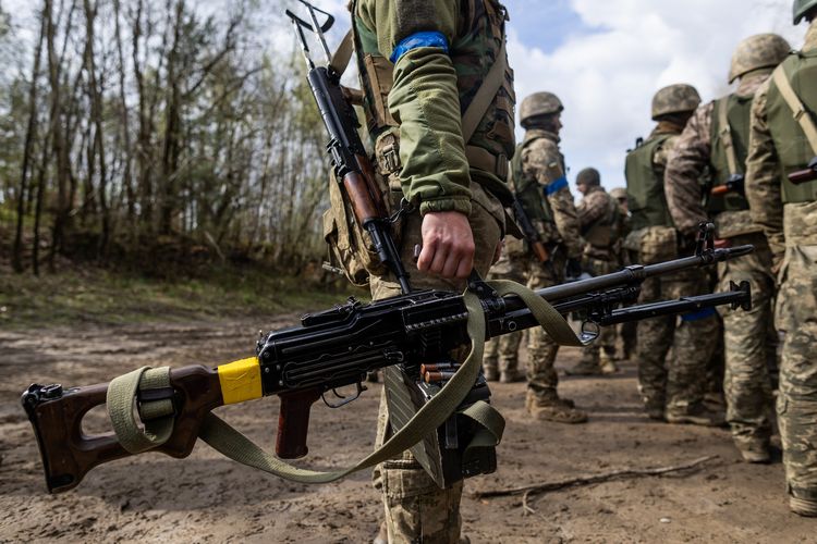 Tentara Ukraina membawa senapan mesin saat latihan militer bersama pasukan Perancis di lokasi yang dirahasiakan di Polandia para 4 April 2024. Latihan ini digelar saat perang Rusia-Ukraina masih berkecamuk.
