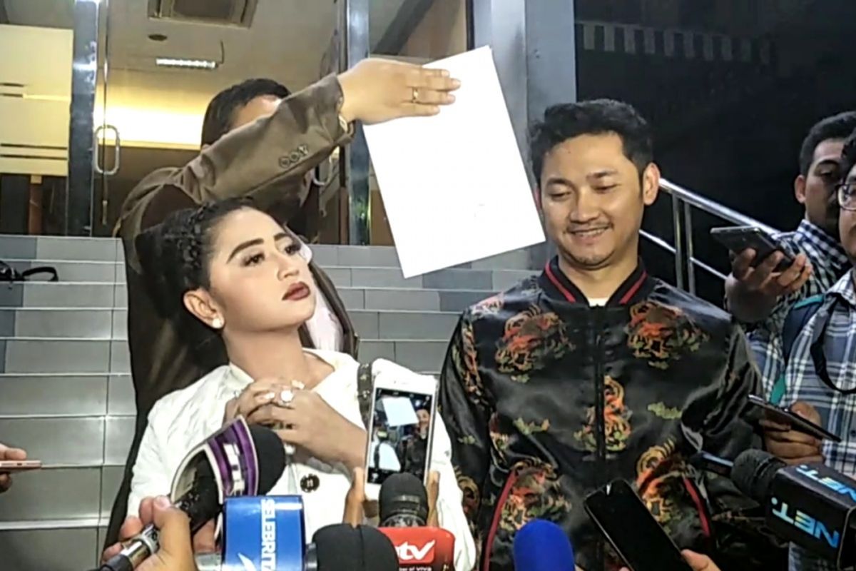 Dewi Perssik (kiri) mendampingi suaminya Angga Wijara (kanan) melaporkan seorang petugas Transjakarta ke Sentra Pengaduan Kepolisian Terpadu (SPKT) Polda Metro Jaya, Senin (4/12/2017) malam.