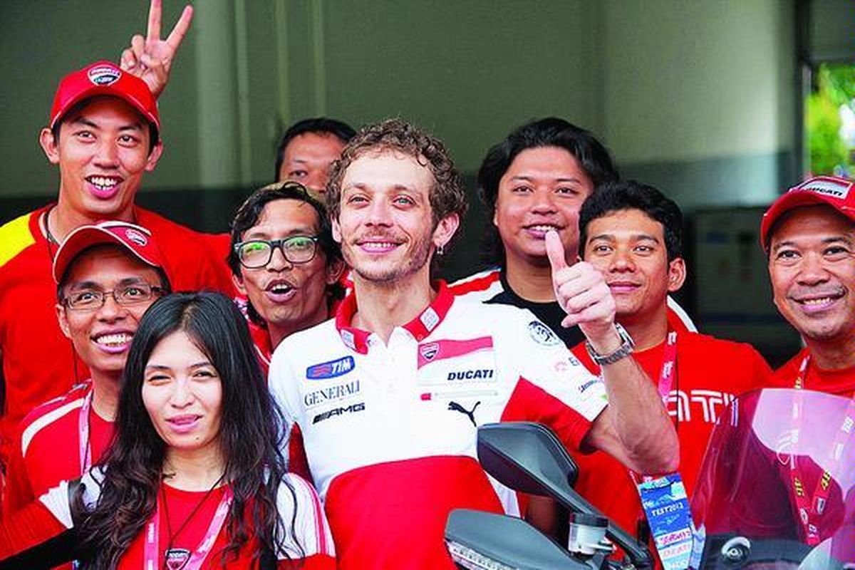 Pebalap Ducati Marlboro,  Valentino Rossi, berpose dengan penggemarnya di sela-sela latihan uji coba MotoGP di Sirkuit Sepang, Malaysia, Rabu (29/2).