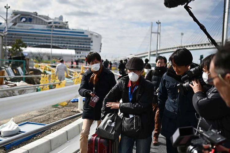 Para penumpang kapal pesiar Diamond Princess yang dinyatakan tidak negatif virus corona keluar setelah menjalani karantina, di Terminal Daikoku Pier Cruise di Yokohama, Jepang, Rabu (19/2/2020). Setidaknya 500 penumpang diizinkan keluar setelah dikarantina selama 14 hari, menyusul kabar terdapat 542 penularan positif corona di dalam kapal tersebut.