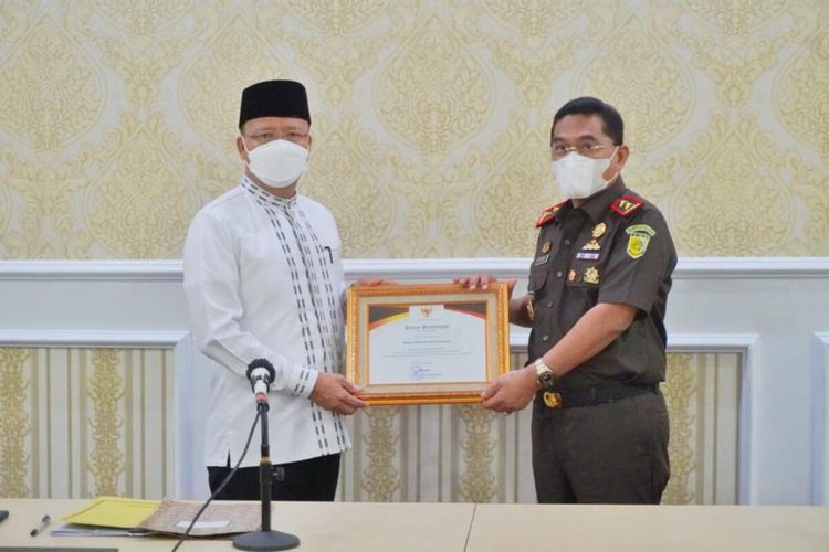 Gubernur Rohidin Mersyah memberikan penghargaan pada Kajati Bengkulu, Heri Jerman karena berhasil mengembalikan tanah negara