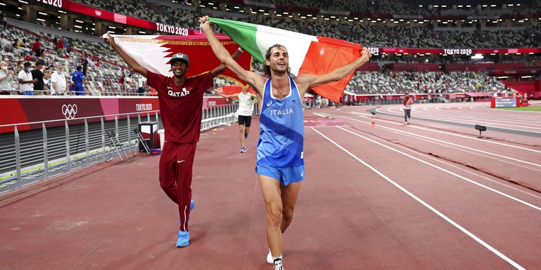Peraih medali emas Mutaz Barshim, kiri, dari Qatar, dan Gianmarco Tamberi, dari Italia, merayakan kemenangan setelah berbagi emas setelah final lompat tinggi putra di Olimpiade Musim Panas 2020, Minggu, 1 Agustus 2021, di Tokyo, Jepang. 