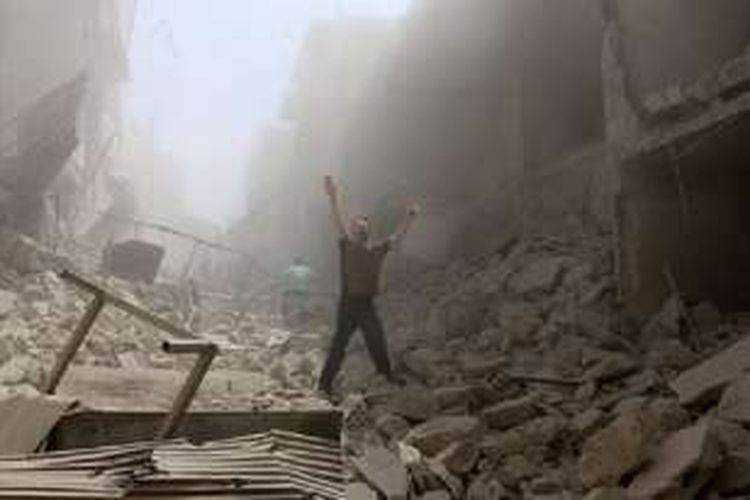 Seorang pria berada di di tengah bangunan yang hancur akibat serangan udara Rusia di kawasan  al-Kalasa, Aleppo.