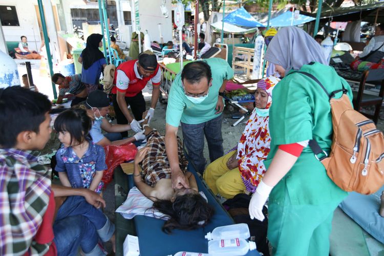 Pasien Rumah Sakit Anuta Pura terpaksa dirawat di halaman rumah sakit  akibat gempa bumi yang mengguncang Kota Palu, Sulawesi Tengah, Minggu (30/9/2018). Gempa bermagnitudo 7,4 mengakibatkan ribuan bangunan rusak dan sedikitnya 420 orang meninggal dunia.